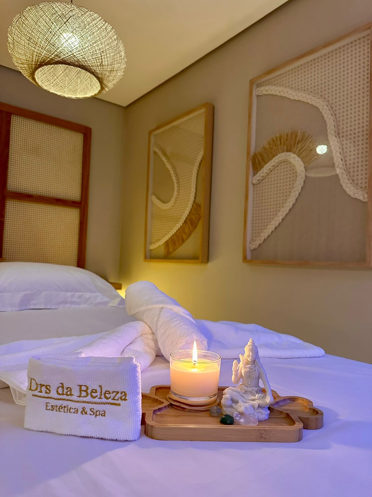 Detalhe da sala de SPA da Drs da Beleza com vela, toalha e maca